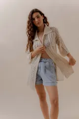 Saco calado color crudo, tejido a máquina con mezcla de algodón y poliéster, de corte recto y mangas 3/4.