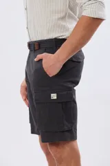 Bermuda cargo color azul marino, de gabardina con bolsillos laterales con solapa en las piernas y presillas para cinturón. Incluye cinturón de lona trenzada oscura con detalles en cuero sintético y hebilla metálica.