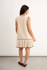 Vestido corto de punto color bordó con detalles en celeste claro en el cuello, sisas y el ruedo, sin mangas y con diseño evasé.
