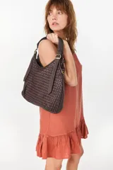 Cartera de cuero marrón oscuro con diseño trenzado y asa ajustable.
