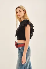 Camisa corta de voile de algodón negro, con escote redondo y mangas con volados decorados con puntilla de algodón bordada.