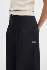 Pantalón wide leg de algodón color negro, con cintura ajustada, pinzas delanteras y bolsillos de ojal en la espalda.