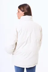 Campera puffer de corte holgado, color negro, con cuello alto, cierre frontal y puños elásticos.