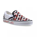Zapatillas Vans sin cordones, con estampado a cuadros blancos y negros con dibujos de Condorito. La suela es blanca con dibujos de Condorito y la plantilla es negra.