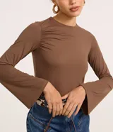 Blusa ajustada de manga larga color marrón, con cuello redondo y fruncido en los hombros y laterales.