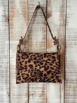 Cartera tipo bolso con estampa animal print de leopardo, solapa frontal con cierre metálico de broche y correa ajustable con detalles de nudos.