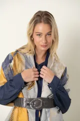 Cinto de cuero con elástico, color tostado metalizado y hebilla ovalada metálica plateada.