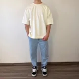Remera oversize de algodón pesado en color blanco off-white, con un gran estampado fotográfico en blanco y negro en la espalda acompañado de texto.