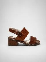 Sandalias de cuero marrón, con taco cuadrado y diseño de doble tira ancha: una lisa en la puntera y otra con textura tipo cocodrilo en el empeine. Posee tira en el talón con hebilla metálica ajustable.