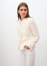 Chaqueta de tweed de corte recto color blanco, con cuello redondo, manga larga, bolsillos de parche delanteros y terminaciones deshilachadas. Cuenta con forro interior y cierre frontal de botones.