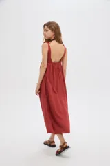 Vestido midi negro de viscosa con cuello cuadrado y tirantes finos ajustables con lazo en los hombros, de corte holgado y diseño fluido.