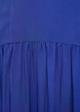 Vestido midi de color azul, sin mangas, con tirantes anchos y cuello escotado cuadrado. Presenta un diseño ajustado en el torso con corte evase y falda de corte midi con vuelo.