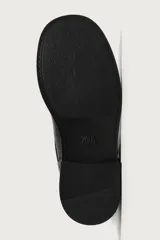 Bota de media caña color negro con horma cuadrada, suela con ligero tacón y ajuste mediante dos tiras con hebilla metálica, una en el empeine y otra en la parte superior de la caña.