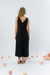 Vestido largo de lino con escote en V, diseño recto y fluido, con cierre frontal abotonado mediante botones de madera.