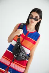 Riñonera negra de cuero vacuno con correa regulable, cierre superior con doble cremallera y bolsillo frontal con cremallera.