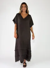 Vestido largo negro de lino, con escote en V, mangas cortas y detalles de flecos en el cuello, mangas y ruedo.