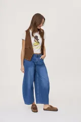 Jean de tiro medio y corte barrel con pierna amplia y ligeramente curva, estilo de cinco bolsillos en denim negro lavado.