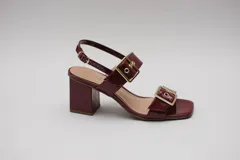 Sandalias negras acharoladas con doble hebilla y taco cuadrado.