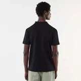 Remera polo negra de manga corta, confeccionada en tejido con textura de nido de abeja, con cuello camisero y cierre frontal parcial de cremallera.