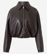 Campera de cuero sintético con diseño balonê, cuello camisero, cierre frontal con cremallera, mangas largas y ruedo elástico.