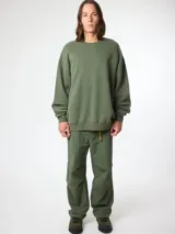 Buzo verde militar de cuello redondo, corte oversize y diseño liso.