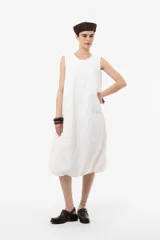Vestido midi blanco de silueta amplia y relajada, sin mangas, con escote redondo y diseño abombado en la parte inferior.