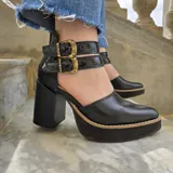 Zapatos de taco alto con plataforma, confeccionados en cuero color beige en la puntera y marrón tostado en el talón y las tiras con doble hebilla metálica. Cuentan con taco ancho efecto madera.