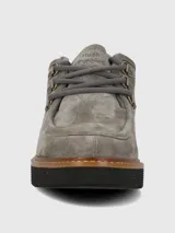 Zapatos de gamuza color gris de la marca Hush Puppies, modelo Renovo. Presentan diseño robusto con cordones gruesos, ojales metálicos, suela gruesa track y costuras pespunteadas en el borde.