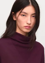 Jersey de punto fino color bordó, con cuello drapeado y diseño de corte recto con mangas largas.