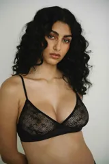 Soutien tipo triángulo sin aro, color negro, confeccionado en encaje floral. Presenta un cruce central en el busto y breteles finos regulables en la espalda.