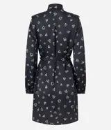 Vestido corto modelo chemise, color negro con estampado de corazones blancos, de manga larga abullonada con hombreras y puños ajustados. Incluye cinturón para lazo en la cintura.