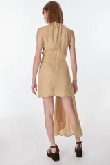 Vestido corto color marrón, con cuello halter fruncido y drapeado asimétrico en la cintura que genera una cola larga.