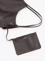 Bolso tipo hobo confeccionado en cuero vacuno negro con efecto rugoso y acabado suave. Presenta manijas finas para llevar al hombro, costura central vertical y un pequeño llavero de cuero colgante con el logo de la marca.