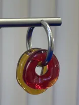 Aros tipo argolla de plata 925 con dijes circulares de vidrio en colores rojo y ámbar.