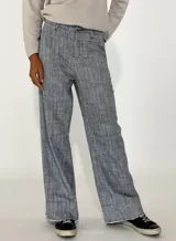 Pantalon de corte recto y tiro medio, confeccionado en tejido con textura jaspeada en tonos grises y azules, con ruedo desflecado.