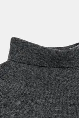Jersey de punto liso color gris oscuro, con cuello subido y diseño de manga murciélago con sisa amplia que se ajusta hacia la muñeca.
