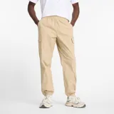 Pantalón cargo New Balance color beige, con cintura elástica, bolsillos laterales tipo cargo y puños elásticos en los tobillos.