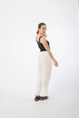 Pantalón de tela color beige, con cintura alta elastizada y cordón ajustable.