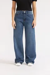 Jeans de mezclilla de corte wide leg, tiro medio y color azul medio con costuras en tono caramelo.