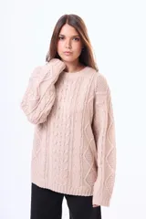 Buzo tejido de punto con diseño de trenzas y rombos, cuello redondo y mangas largas. Presenta un calce holgado y terminaciones acanaladas en puños y ruedo.