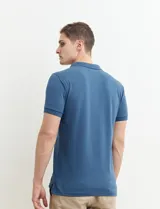 Remera polo azul marino con estampado de pequeños puntos blancos, cuello clásico con tres botones y mangas cortas.