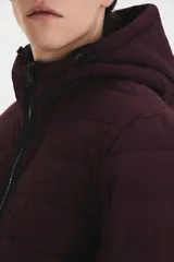 Campera puffer con capucha y cierre frontal, color bordó, de calce estándar con puños y cintura elastizados en negro.