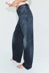 Jeans de tiro medio con diseño tipo balloon, cinco bolsillos y bajo ajustable con trabilla y botones. Cierre frontal con cremallera y botón metálico.