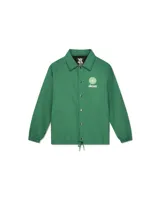 Chaqueta tipo coach verde con cuello camisero, cierre frontal de botones a presión y cordón ajustable en el ruedo. Presenta un logo circular blanco con texto en el pecho izquierdo.