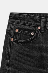 Jeans de tiro medio con diseño wide leg y pernera ancha, estilo de cinco bolsillos, cierre frontal con cremallera y botón metálico.