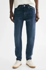 Jean de cinco bolsillos en denim de algodón, de corte estándar y piernas ajustadas, con lavado azul y efecto deslavado.