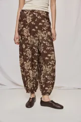 Pantalón de tiro alto y silueta amplia con estampado floral, pinzas en el frente, volumen relajado y terminación elastizada en los tobillos.