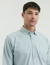 Camisa de tejido Oxford con cuello button-down, manga larga y bolsillo frontal. Presenta botones al tono y un corte clásico.