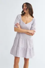 Vestido corto de algodón con estampado de cuadros vichy en color lila y blanco, escote corazón, mangas cortas abullonadas y falda escalonada con volantes.