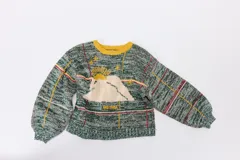 Sweater de punto con diseño geométrico y gráfico frontal en color rojo. Presenta cuello redondo, mangas largas holgadas y un ajuste suelto.